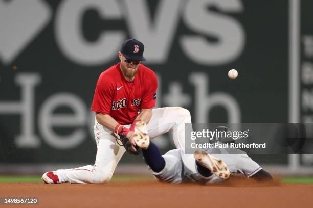 Brenton Doyle of the Colorado Rockies slides past Christian Arroyo of the Boston Red Sox during the sixth inning at Fenway Park on June 14, 2023 in...