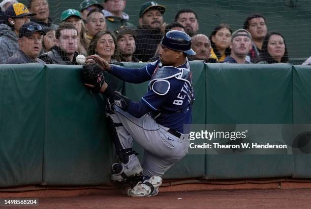 Christian Bethancourt of the Tampa Bay Rays can't collides with the wall causing him to drop a foul pop-up hit by Ryan Noda of the Oakland Athletics...