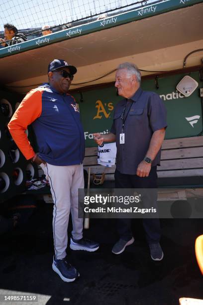 Manager Dusty Baker Jr. #12 of the Houston Astros with former umpire Ed Montague in the dugout before the game against the Oakland Athletics at...