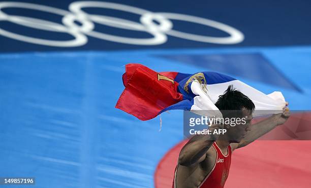 Russia's Roman Vlasov celebrates with his country's flag after defeating Arsen Julfakayan of Armenia during their London 2012 Olympic Games 74kg...