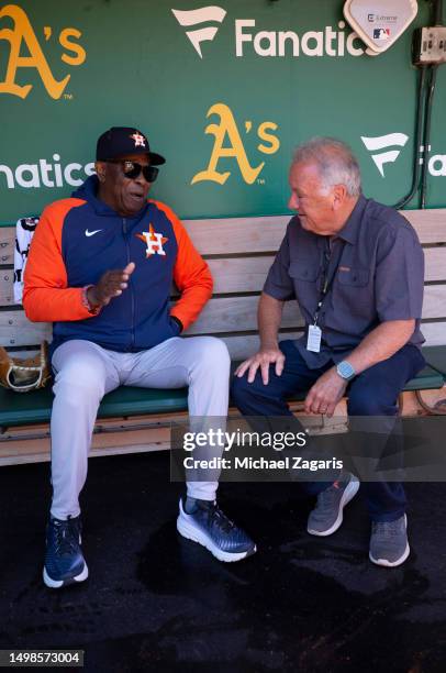 Manager Dusty Baker Jr. #12 of the Houston Astros with former umpire Ed Montague in the dugout before the game against the Oakland Athletics at...