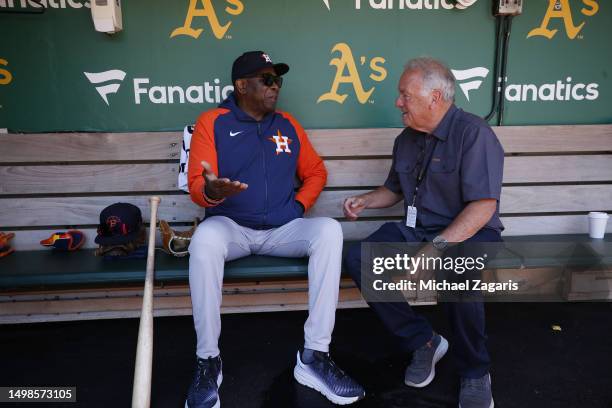 Manager Dusty Baker Jr. #12 of the Houston Astros with former umpire Ed Montague in the dugout before the game against the Oakland Athletics at...