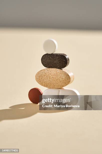 pills, vitamins and nutritional supplements on a beige background are folded in bizarre figures. - ストレプトミセス ストックフォトと画像