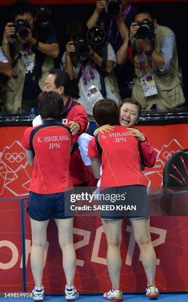 Japan's table tennis players Sayaka Hirano , Ai Fukuhara and Kasumi Ishikawa embrace as they celebrate after beating Singapore in the women's team...