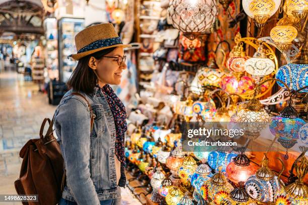 young woman looking at mosaic lamps at the grand bazaar in istanbul - grand bazaar istanbul stock pictures, royalty-free photos & images