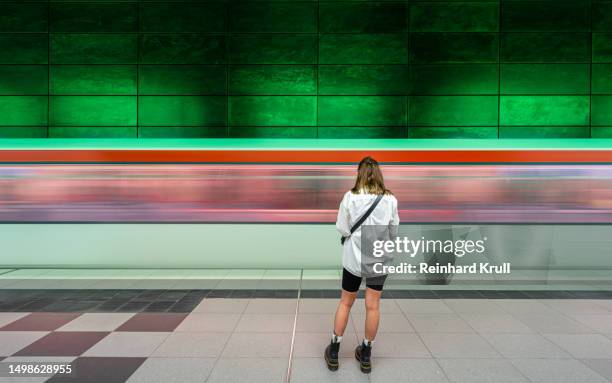 rear view of woman against arriving subway train - metro hamburg stock pictures, royalty-free photos & images