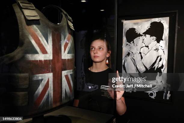 Event marshal Matilda Lask stands next to the Stormzy stab proof vest which he wore at Glastonburry festival and the Stencil and the kissing...