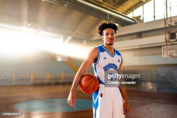 basketball player standing on court - basketball uniform stock pictures, royalty-free photos & images