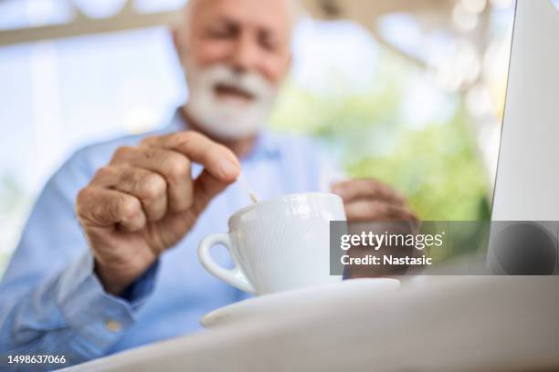 senior man pouring sugar into coffee - sweetener packet stock pictures, royalty-free photos & images
