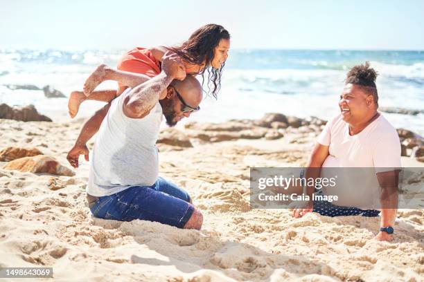 gay male couple playing with daughter on sunny ocean beach - couple at beach sunny stock pictures, royalty-free photos & images