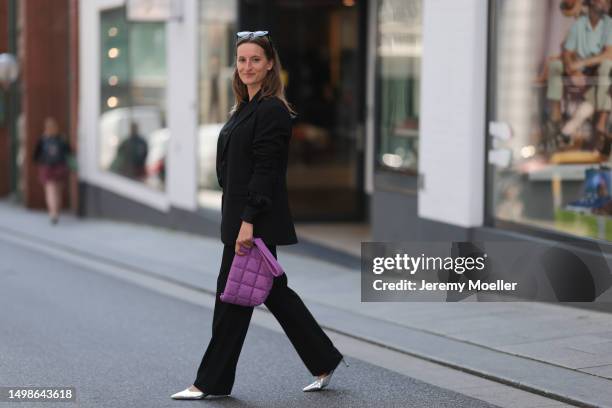 Marlene Fey wearing purple VeeCollective bag, silver Celine heels, black SoSue suit, black Celine shades on June 08, 2023 in Hamburg, Germany.