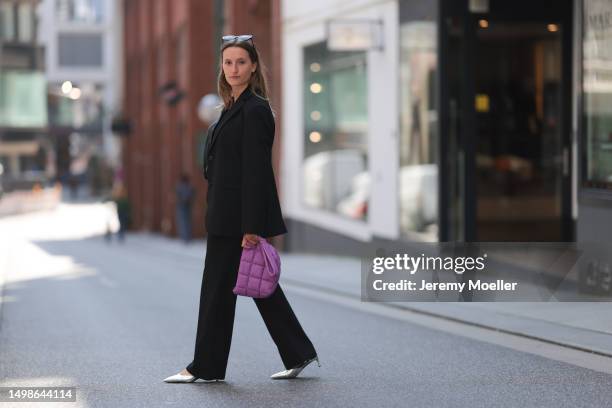 Marlene Fey wearing purple VeeCollective bag, silver Celine heels, black SoSue suit, black Celine shades on June 08, 2023 in Hamburg, Germany.