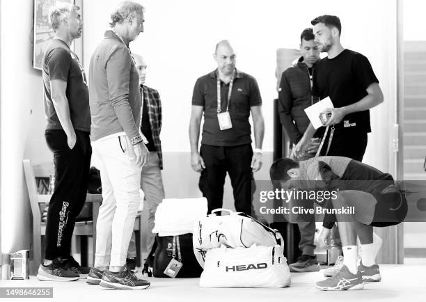 Novak Djokovic of Serbia stretches as his team look on moments before walking out on to the court for his second round match on Day 4 of the 2023...