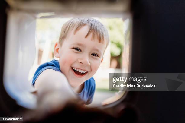 4 years old boy looking through the cat flap - doggie door stock pictures, royalty-free photos & images