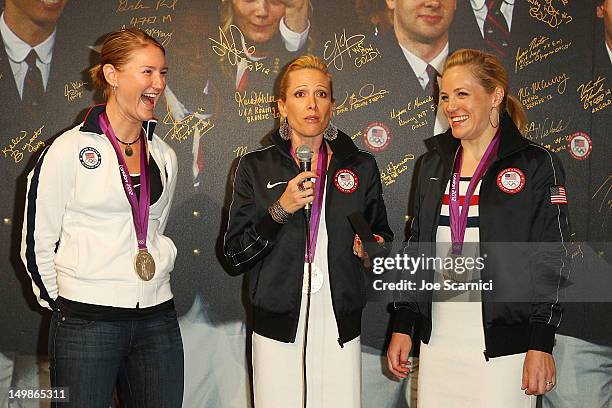 Olympians Lauren Tomayo, Dotsie Bausch and Jennie Reed present their coach with the Order of Ikkos medal during their visit to the USA House at the...