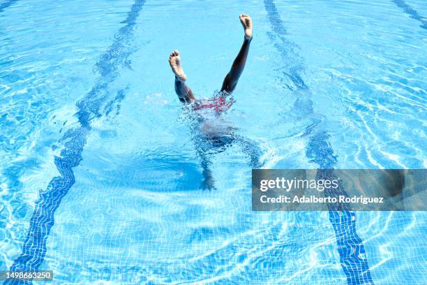 photo of a person enjoying a refreshing swim in a crystal clear pool - boy swimming pool goggle and cap stock pictures, royalty-free photos & images