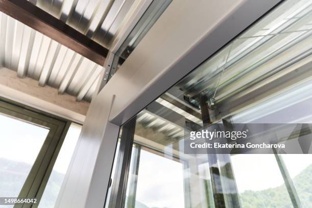glass elevator cabin from the top floor of the house - lift roof stock-fotos und bilder