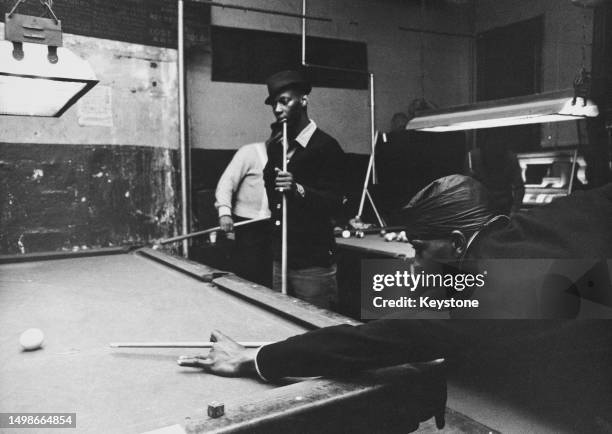 Young men playing pool at a pool hall in the Harlem neighbourhood of Upper Manhattan, New York City, New York, circa 1975.