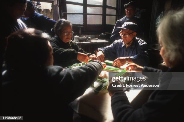 View of a group of people as they play Mahjong, Shanghai, China, 1980s or 1990s.