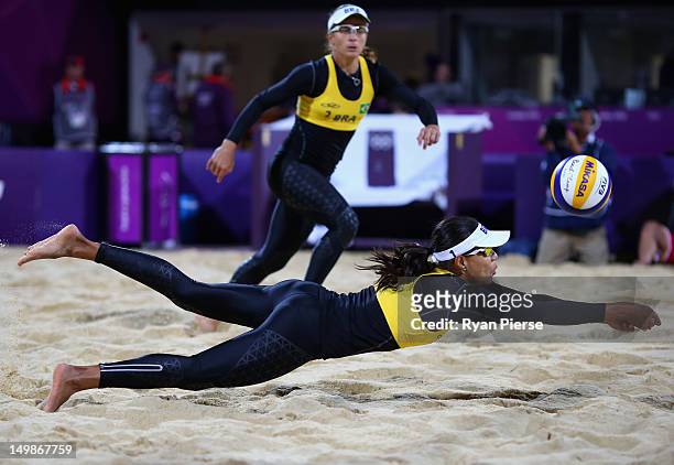 Juliana Silva of Brazil dives for the ball as Larissa Franca of Brazil looks on during the Women's Beach Volleyball Quarter Final match between...
