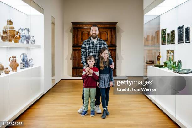 portrait of single father standing with two young children in museum - lean in collection father stockfoto's en -beelden