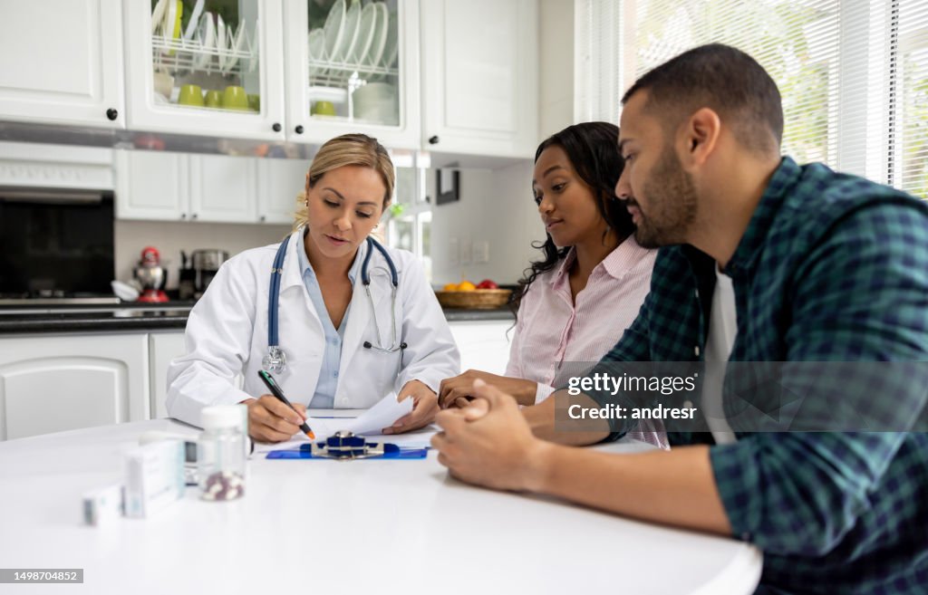 Doctor on a house call talking to a couple at their home