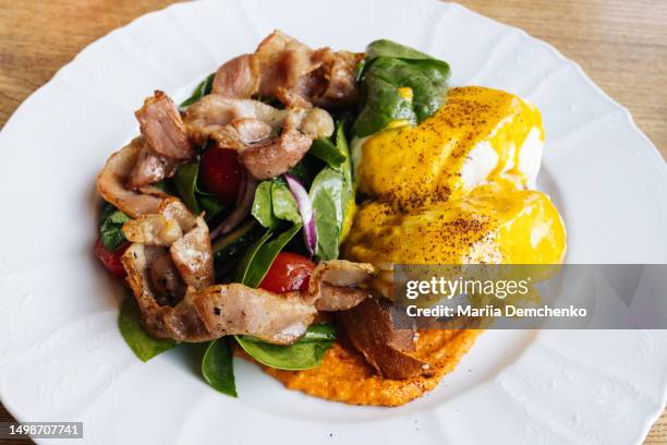 two eggs benedict with fresh salad and fried bacon - mustard sauce stock pictures, royalty-free photos & images
