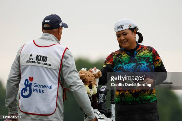Christina Kim of the United States hands her caddie a club on the first green during the first round of the Meijer LPGA Classic for Simply Give at...