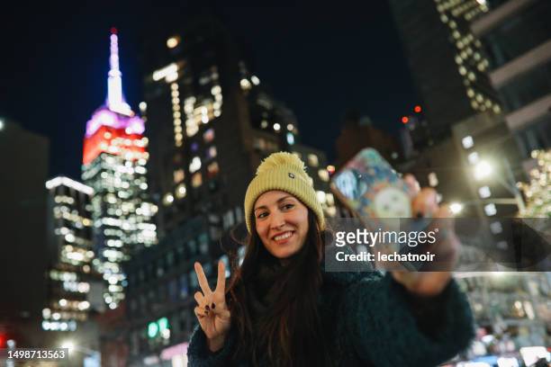 new yorker woman sending a selfie via messaging app - christmas newyork stockfoto's en -beelden