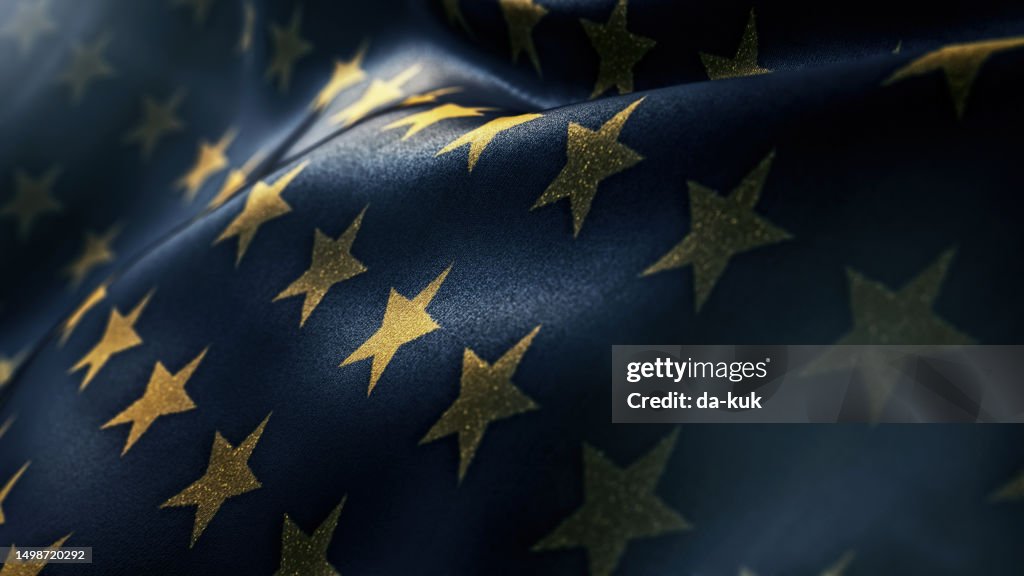 Glänzende goldene Sterne auf dunkelblauem wehendem Flaggenurlaubshintergrund