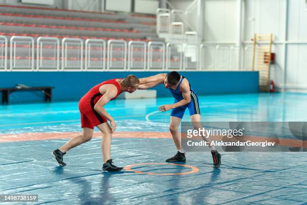 wrestling match between two male competitors - wrestling team stock pictures, royalty-free photos & images