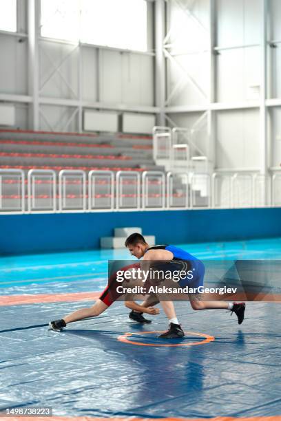 single leg takedown shot by wrestler during competition - greco roman imagens e fotografias de stock