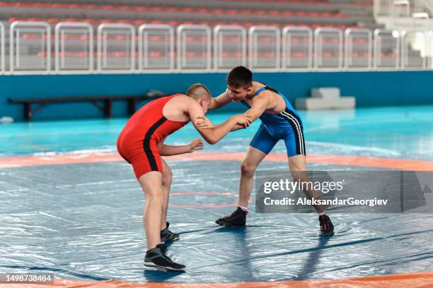 blue vs red during wrestling match - westler stock pictures, royalty-free photos & images