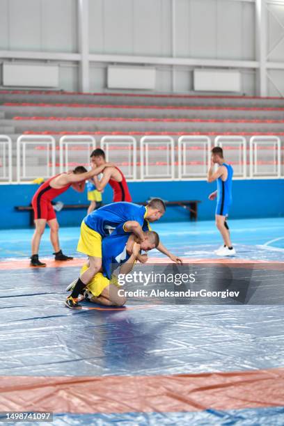 arm throw practiced by wrestlers in gym - young amateur stock pictures, royalty-free photos & images