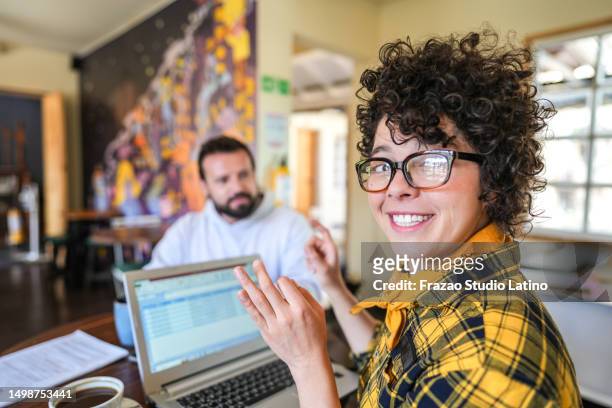 portrait of a deaf woman talking in sign language to coworker at a coffee shop - hearing loss at work stock pictures, royalty-free photos & images
