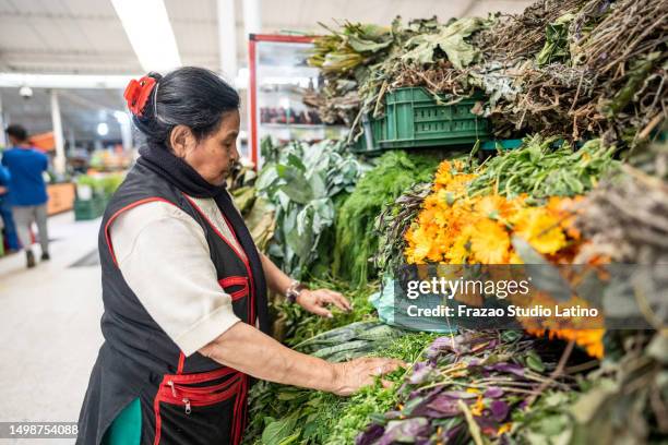 senior female retail clerk working on a greengrocer's shop - marktplein stockfoto's en -beelden