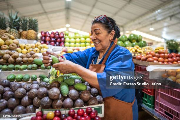 leitende einzelhandelskauffrau, die in einem gemüseladen arbeitet - gemüseladen stock-fotos und bilder