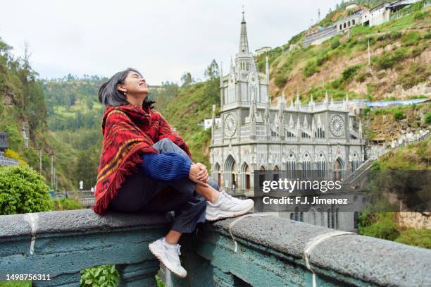 colombian woman with ruana sitting in front of church in las lajas, colombia - pasto stock pictures, royalty-free photos & images