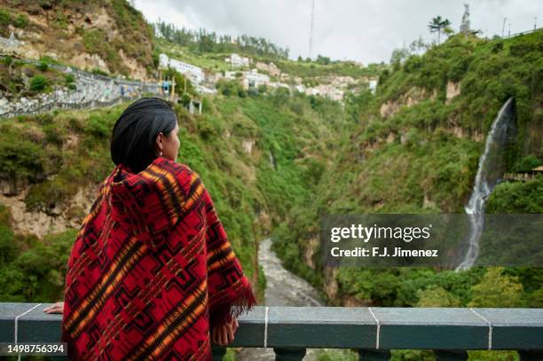 colombian woman with ruana looking towards mountainous landscape with waterfall - pasto stock pictures, royalty-free photos & images