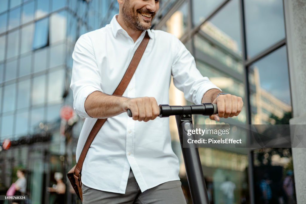 Homem andando de scooter elétrica enquanto se desloca para o trabalho