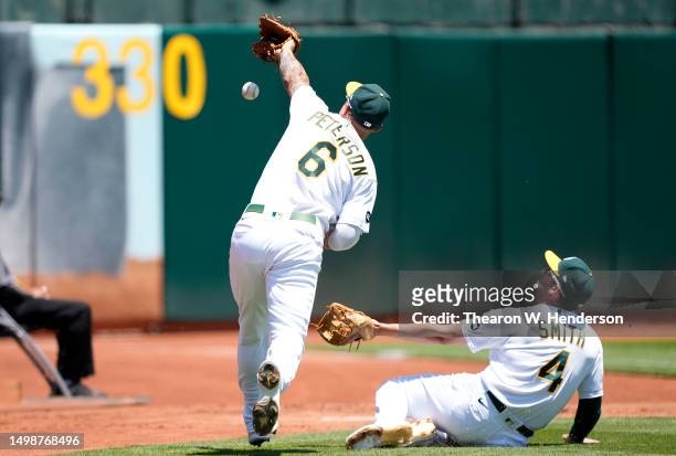 Jace Peterson and Kevin Smith of the Oakland Athletics avoid colliding with each other chasing down a foul pop-up hit by Randy Arozarena of the Tampa...