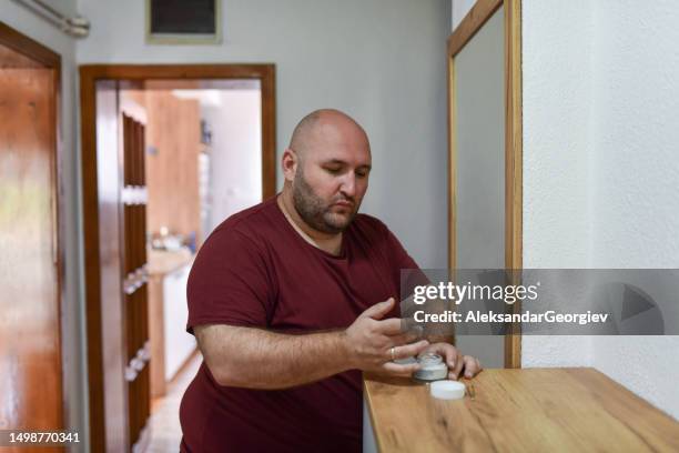 balding male applying facial cream - man eye cream stock pictures, royalty-free photos & images