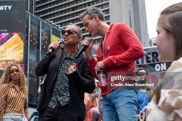 Actors Norbert Leo Butz and Adam Pascal sing during the 'Broadway Day Rally' hosted by the Writers Guild of America East in Times Square on June 15,...