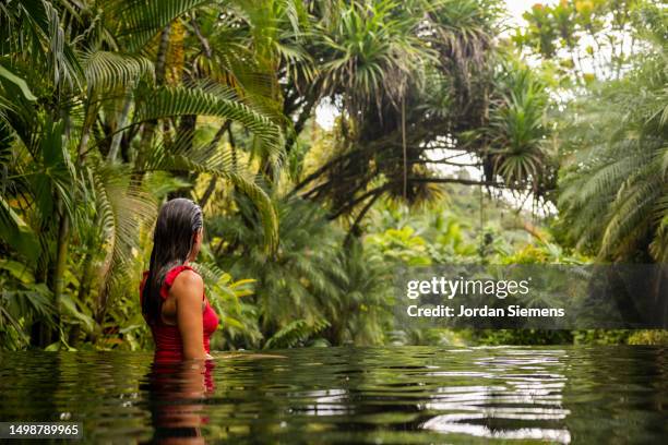 a woman relaxing in a swimming pool in costa rica. - la fortuna stock pictures, royalty-free photos & images