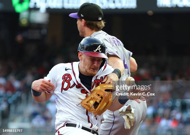 Sean Murphy of the Atlanta Braves collides with Ryan McMahon of the Colorado Rockies as he slides safely into third base on a single by Matt Olson in...