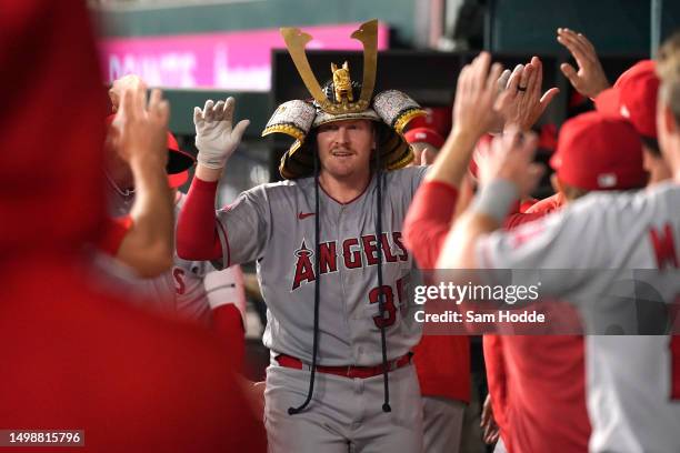Chad Wallach of the Los Angeles Angels is congratulated by teammates in his dugout after hitting a solo home run during the second inning against the...