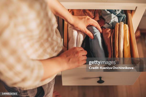 chest of drawers with hand clothes - kleiderschrank stock-fotos und bilder