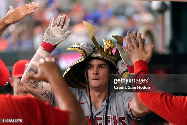 Mickey Moniak of the Los Angeles Angels is congratulated in his dugout after hitting a solo home run during the seventh inning against the Texas...