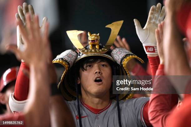 Shohei Ohtani of the Los Angeles Angels celebrates in his dugout after hitting a two-run home run during the eighth inning against the Texas Rangers...