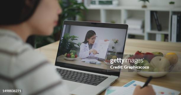young woman on video call with female nutritionist to discuss health care plan - nutritionist stock pictures, royalty-free photos & images
